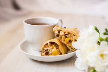 cup of tea, apple strudel pieces, freesia flower