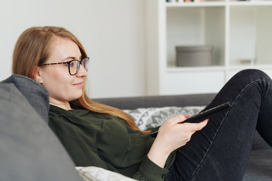 Young woman relaxing at home watching TV