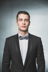 Beautiful fashion man in a suit and a butterfly