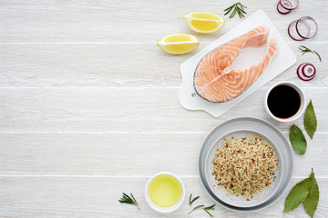 Fresh salmon with ingredients. Light wooden background, top view