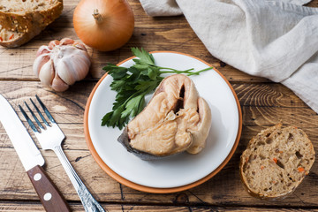 Ingredients for salmon fish soup, pieces of bread, onion and garlic with greens on wooden background.
