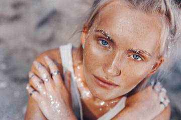 beautiful young fashion model on the beach. Close up portrait of boho model with sparkling boho...