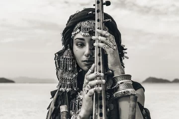 Schöne junge, stilvolle Stammesfrau in orientalischem Kostüm, die im Freien Sitar spielt. Nahansicht © zolotareva_elina