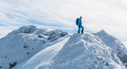 Fototapeta na wymiar Hiker with winter equipment on the snow-ice ridge.