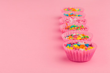 Sugar sprinkles  food background on pink cardboard