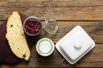 breakfast, cherry jam, milk bottle, slice of bread, old wood table