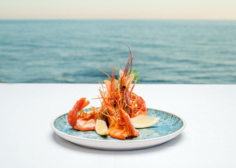 Shrimps on a plate against the background of the sea