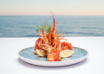 Shrimps on a plate against the background of the sea