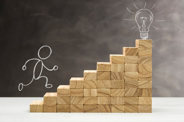 Concept of idea and innovation, light bulb lit on top of a staircase, with human shape rise.