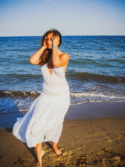 Fototapeta na wymiar Plus size hispanic woman at sea. Young woman with overweight at vacation 