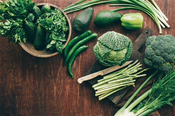 Green vegetables and herbs for cooking healthy meals. Still life photo, toned