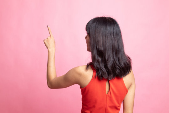 Back of Asian woman touching the screen with her finger.