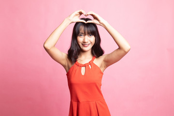 Obraz na płótnie Canvas Young Asian woman gesturing heart hand sign.