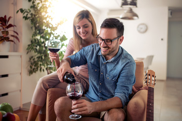 Young couple enjoying wine at home
