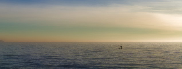 Paddleboarding on open sea solo, watersports with beautiful landscape background, palma, mallorca, spain.