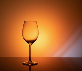 empty glass goblet on orange background