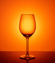 empty glass goblet on orange background