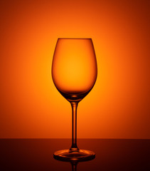 empty glass goblet on orange background