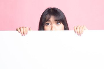 Close up of young Asian woman behind a blank sign.