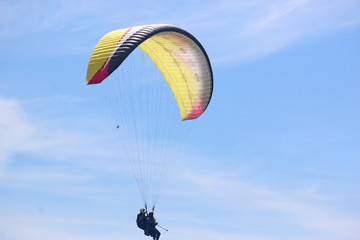 Tandem paraglider flying yellow wing
