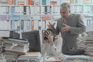Angry boss yelling at his young employee