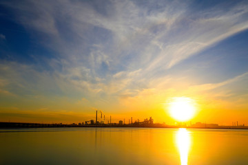 A silhouette of a chemical plant in the setting sun
