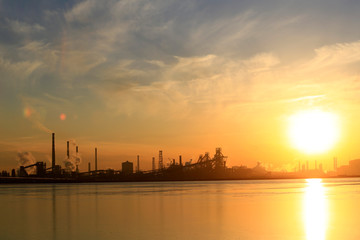 Fototapeta premium A silhouette of a chemical plant in the setting sun