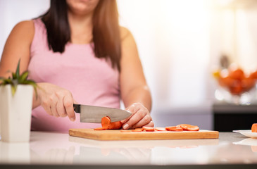 Obraz na płótnie Canvas Pregnant woman cutting vegetables