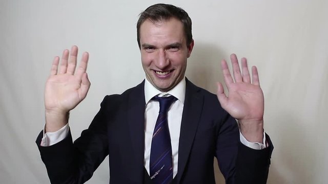 Young beautiful businessman in blue suit smiling and waving her hand greeting customers.Portrait on a white background.