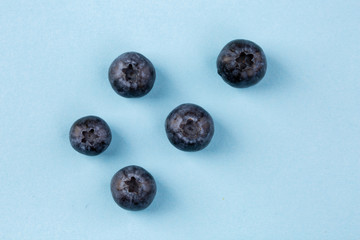 Colorful pattern of blueberries on blue background. From top view