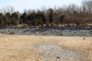 The muddy rocky landscape in the brown grassy surface. 