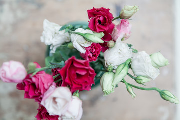 Bouquet of red Eustoma flowers in vase on blurred background