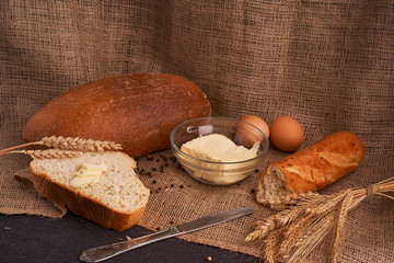 Bakery - gold rustic crusty loaves of bread and buns on black chalkboard background. Still life captured from above