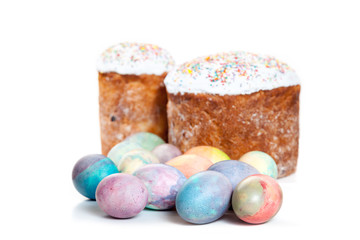 Two Easter cakes and colorful eggs on white background