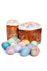 Two Easter cakes and colorful eggs on white background