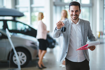 Successful businessman in a car dealership - sale of vehicles to customers