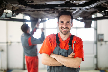 Auto mechanic working in garage. Repair service.