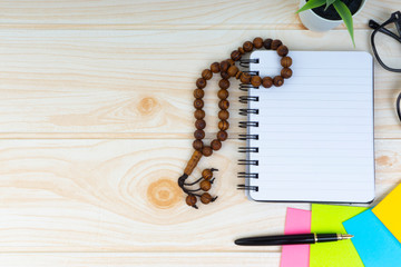 Workspace with Pen, spectacles, decoration flower, rosary and book.Copy Space, business and education concept.