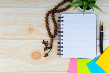 Workspace with Pen, spectacles, decoration flower, rosary and book.Copy Space, business and education concept.