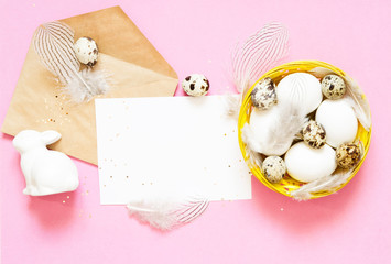 Blank greeting card, kraft envelope. Easter eggs in the basket. Flat lay, top view.