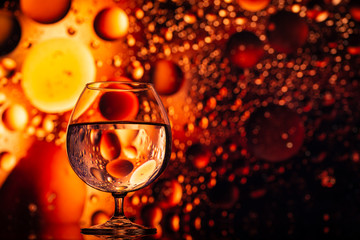 transparent glasses with water with oily drops on colorful background 
