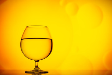 transparent glasses with water with oily drops on colorful background 