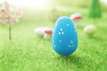 Blue Easter egg outside in grass with evening sun from behind