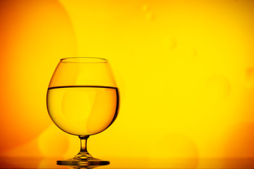 transparent glasses with water with oily drops on colorful background 