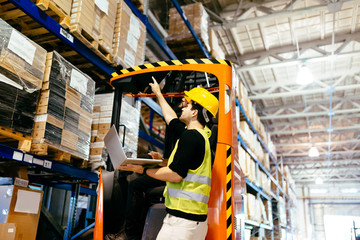 Warehouse workers working together with forklift loader