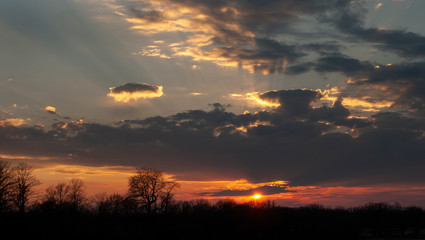 Fototapeta na wymiar Sunset with sunbeams and clouds