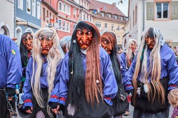 Group of witches in violet black robes. Street Carnival in Southern Germany - Black Forest.