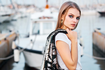 Portrait of young attractive blonde woman posing outdoors
