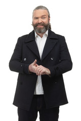 Bearded hipster in a white shirt and jacket rubs his hands on a white background