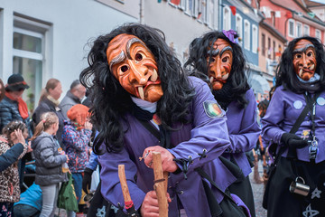 Witch in violet robe looks curious. Street Carnival in Southern Germany - Black Forest.